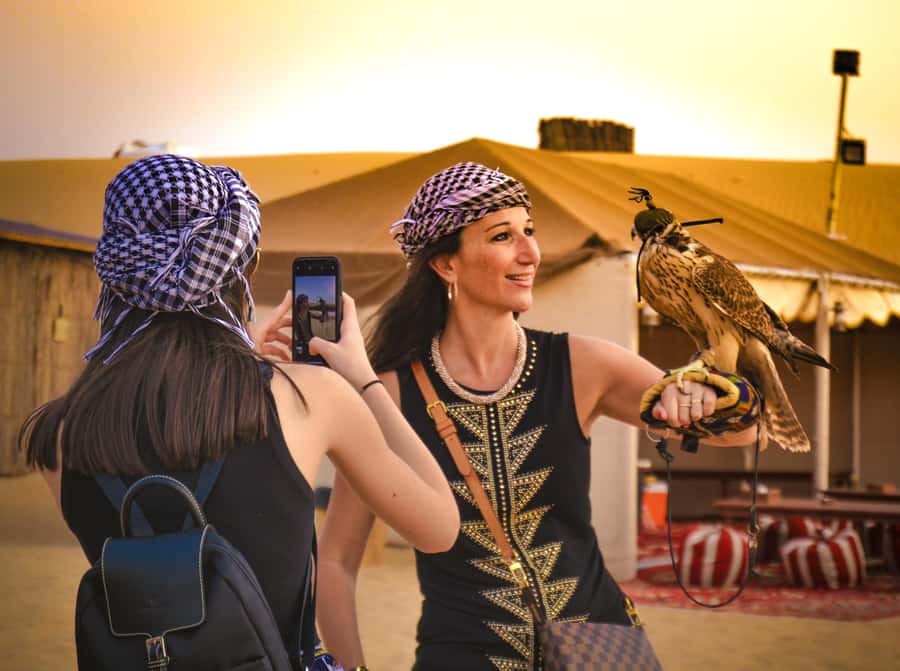 Dubai: Red Dune Desert Safari, Quad Bike, Camels, and BBQ - Desert camp setup: rose water, sweets, henna, shisha, and falcons