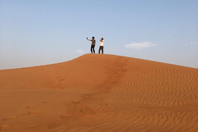Dubai: Unique SUNSET 4WD Red Dunes Safari - Sandboarding at sunset, the perfect mix of wild and graceful